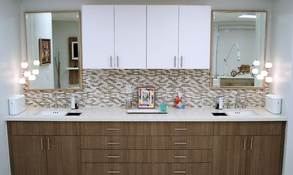A premium hygiene station at Martinez Orthodontics in Miami, featuring dual clinical sinks, designer mosaic tiling, and custom cabinetry for patient convenience.