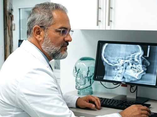 Miami orthodontist Dr. Jesus Martinez, DMD reviewing digital X-rays to plan precise braces and ClearCorrect treatments in Kendall.